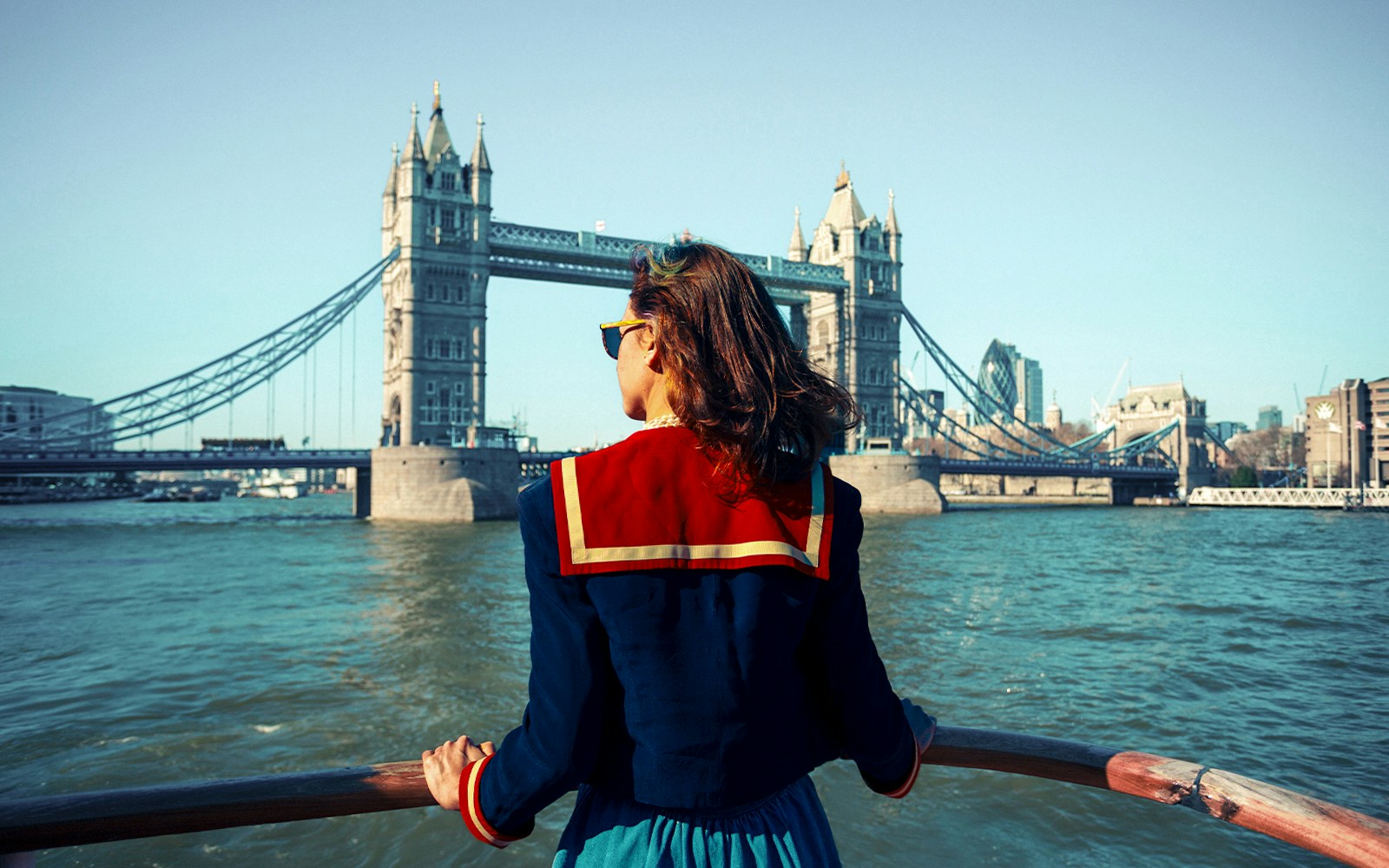 Young woman on a boat viewing Tower Bridge in London.