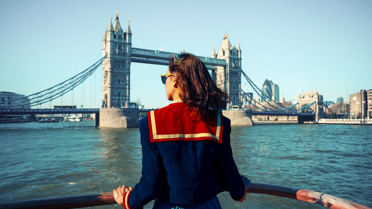 Young woman on a boat viewing Tower Bridge in London.