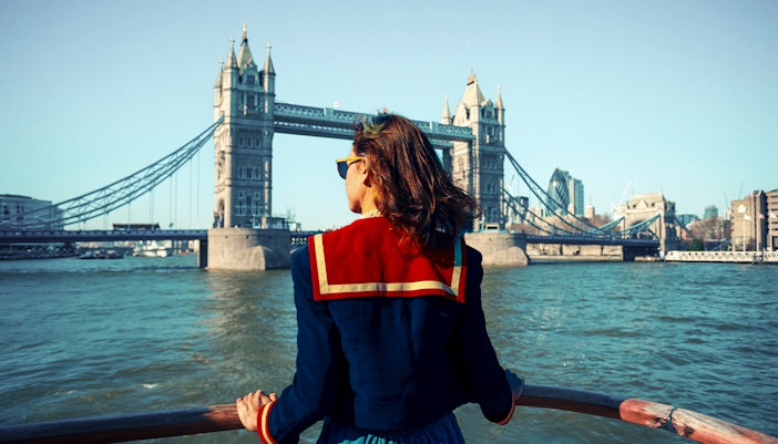 Young woman on a boat viewing Tower Bridge in London.