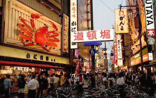 Dotonbori street bustling with people and neon signs during Osaka Night Food Tour.