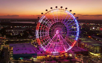 Orlando Ferris wheel lit up at sunset, part of the Orlando Explorer Pass by Go City.