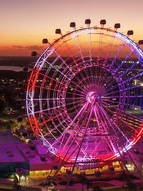 Orlando Ferris wheel lit up at sunset, part of the Orlando Explorer Pass by Go City.