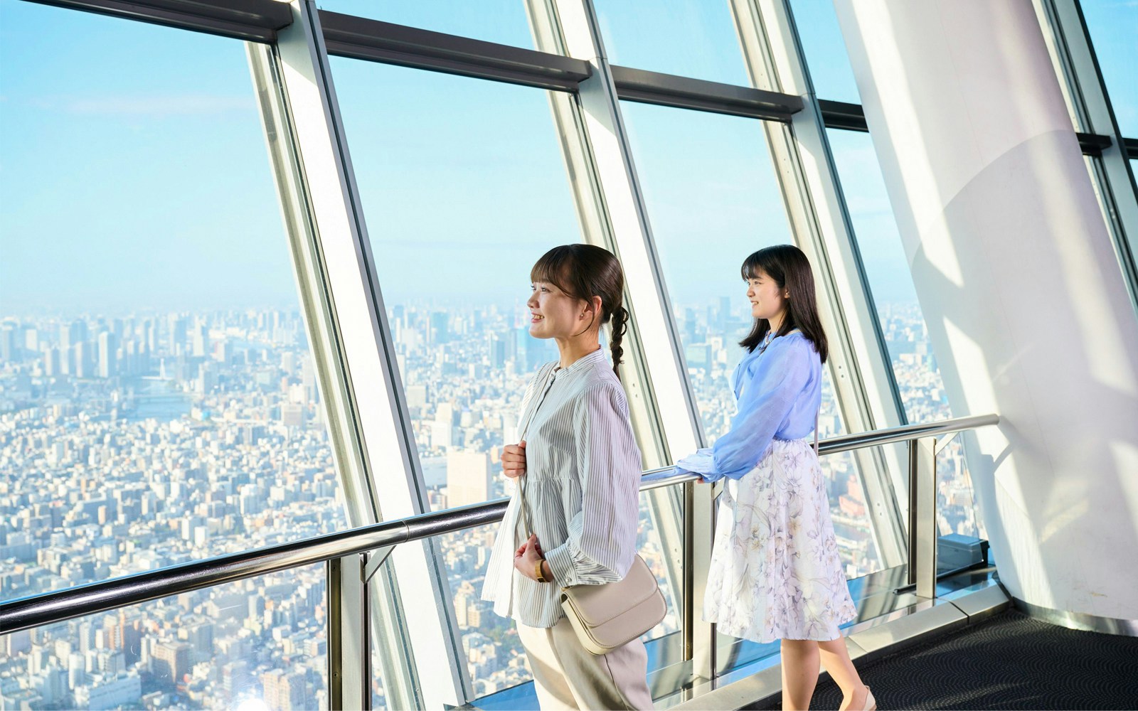 Tourists on Tembo Deck overlooking Tokyo skyline.