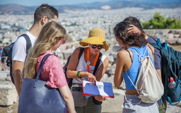 Tour guide explaining Acropolis history to visitors in Athens.