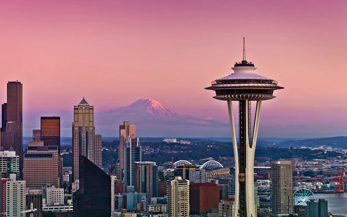 Seattle skyline with Space Needle and Mount Rainier at sunset.