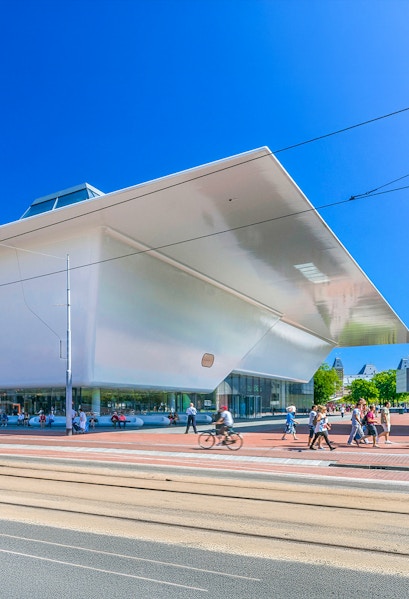 Stedelijk Museum Amsterdam exterior with visitors and cyclist.