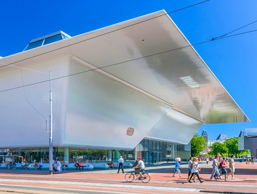 Stedelijk Museum Amsterdam exterior with visitors and cyclist.