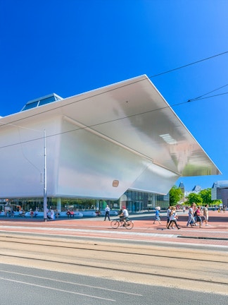 Stedelijk Museum Amsterdam exterior with visitors and cyclist.