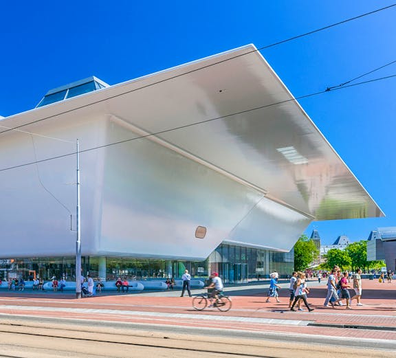 Stedelijk Museum Amsterdam exterior with visitors and cyclist.