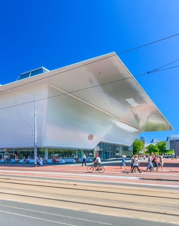 Stedelijk Museum Amsterdam exterior with visitors and cyclist.
