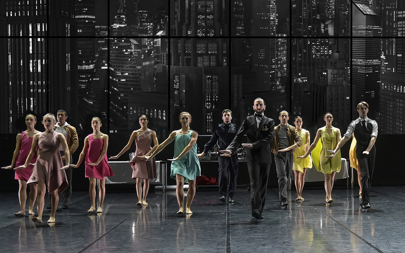 Ballet Preljocaj dancers performing Swan Lake on stage with cityscape backdrop.