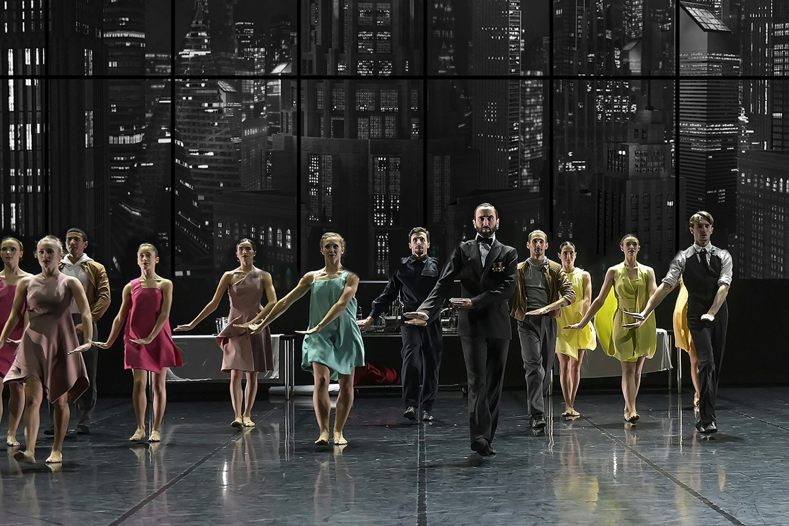 Ballet Preljocaj dancers performing Swan Lake on stage with cityscape backdrop.