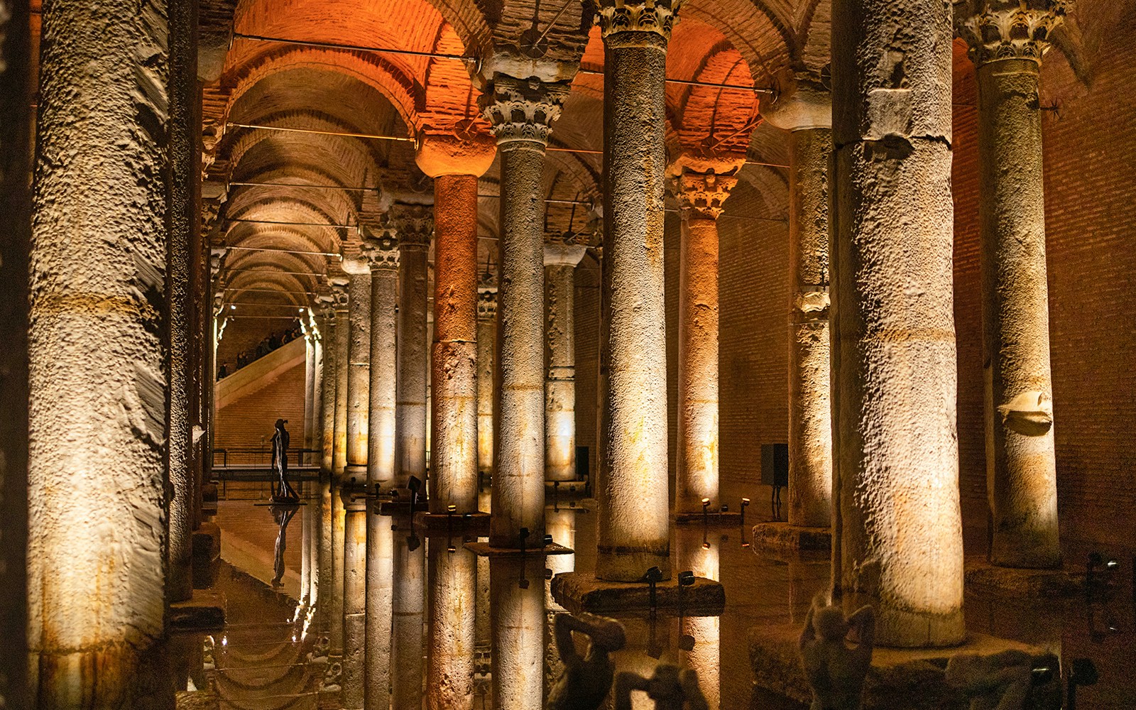Basilica Cistern illuminated columns and reflections on water during guided walking tour in Istanbul.