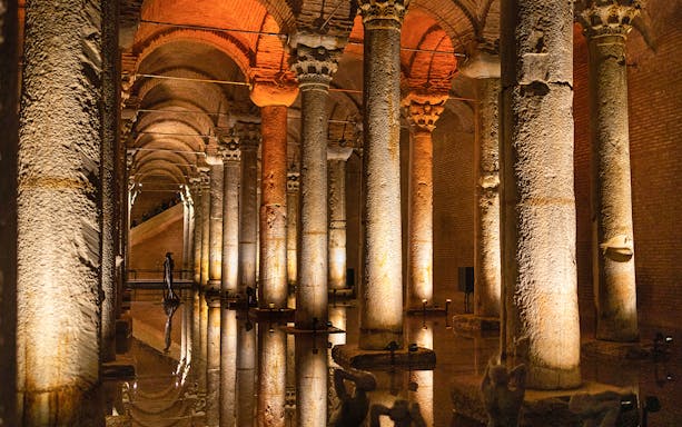 Basilica Cistern illuminated columns and reflections on water during guided walking tour in Istanbul.