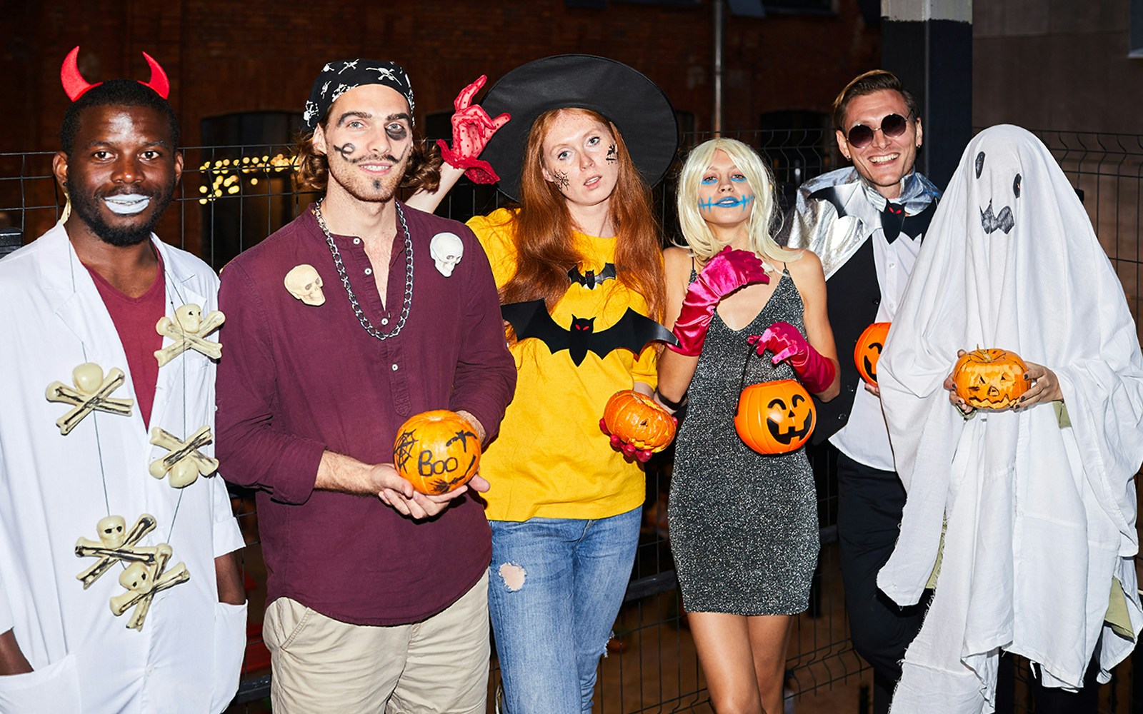People in Halloween costumes holding pumpkins in Las Vegas.