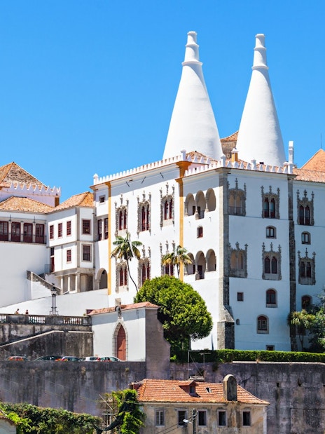 National Palace of Sintra with iconic twin chimneys and lush greenery.