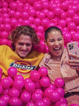 Couple enjoying pink ball pit at Pink Palace Porto.