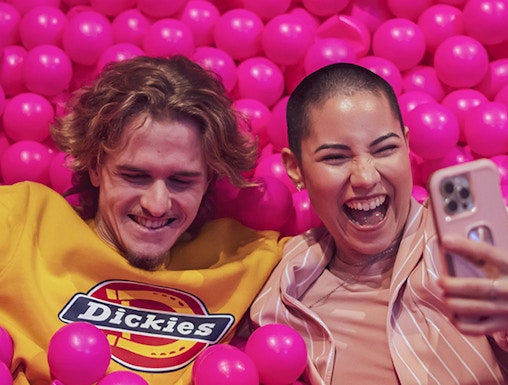 Couple enjoying pink ball pit at Pink Palace Porto.