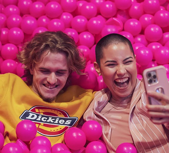 Couple enjoying pink ball pit at Pink Palace Porto.