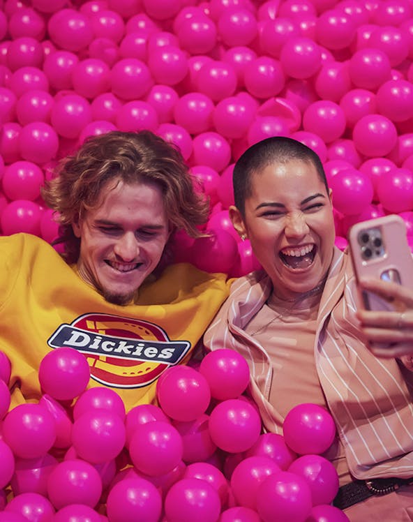 Couple enjoying pink ball pit at Pink Palace Porto.