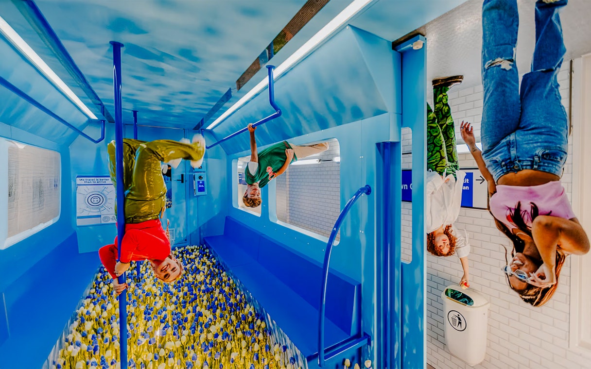 Visitors exploring an upside-down room at The Upside Down Amsterdam.