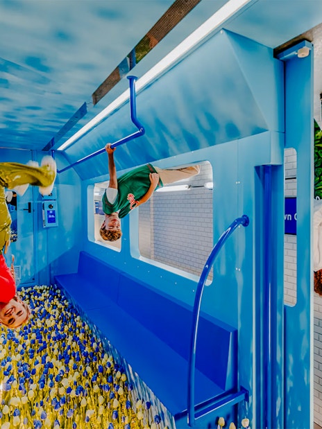 Visitors exploring an upside-down room at The Upside Down Amsterdam.