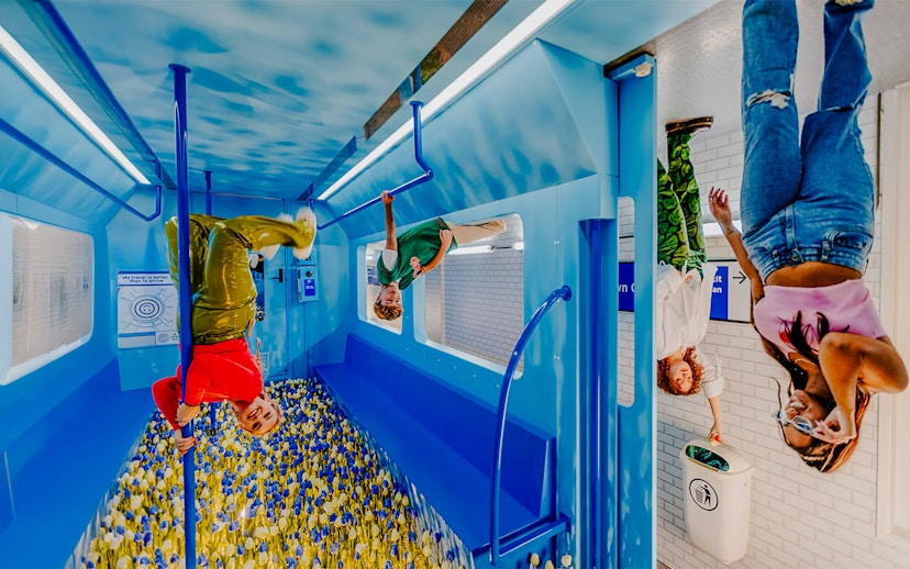 Visitors exploring an upside-down room at The Upside Down Amsterdam.