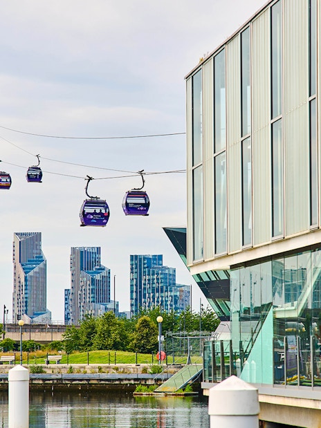 IFS Cloud Cable Car over River Thames in London with city skyline in background.
