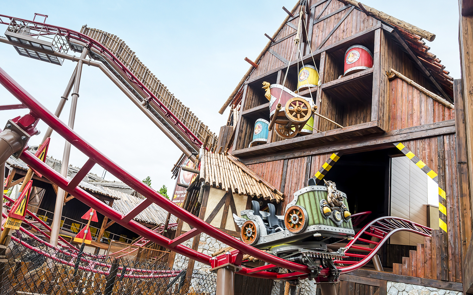Roller coaster at Parc Asterix with themed wooden structure and colorful barrels.