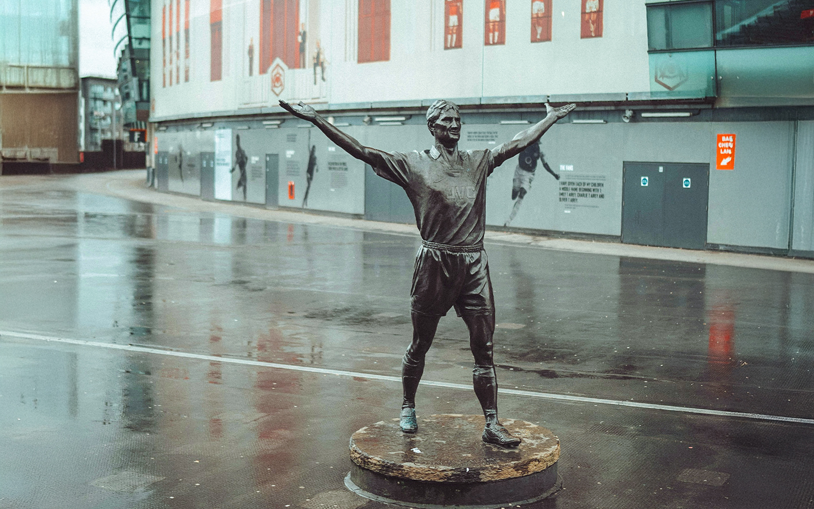 Statue of a footballer with arms raised outside the Emirates Stadium, London.