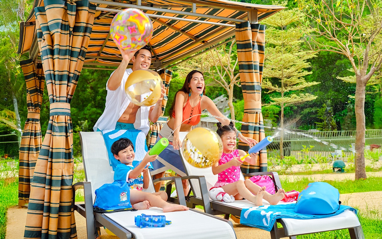 Family playing with water toys by the pool at Water World Ocean Park, Hong Kong.
