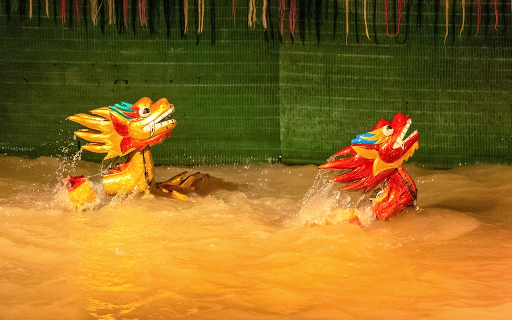 Golden dragon puppets performing in water at the Golden Water Puppet Show.