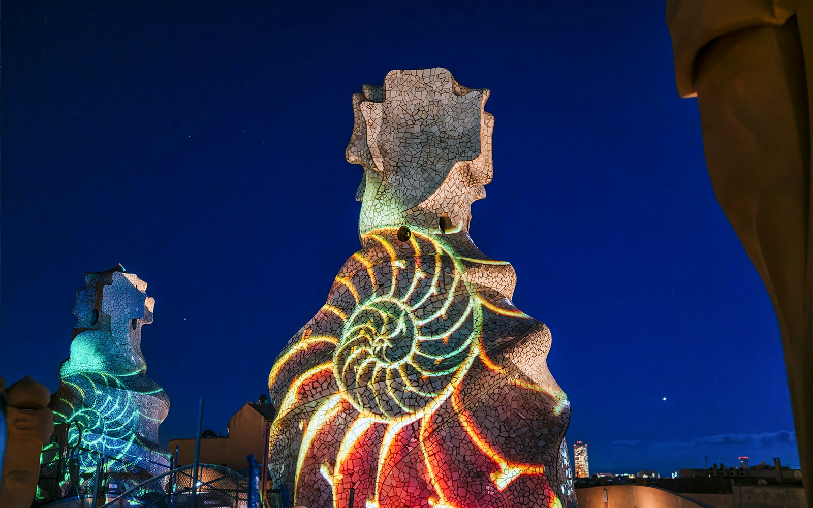 Light projection on Casa Mila chimneys during La Pedrera Night Experience in Barcelona.