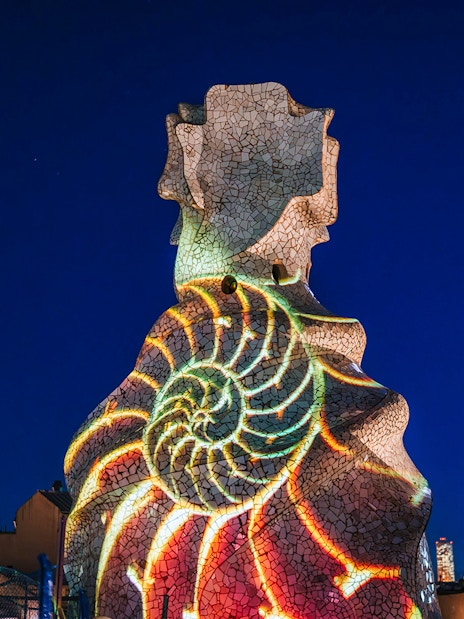 Light projection on Casa Mila chimneys during La Pedrera Night Experience in Barcelona.