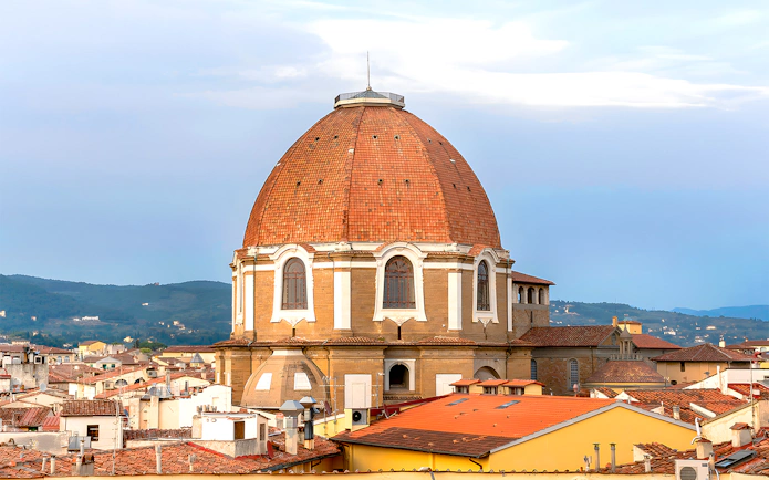 Medici Chapels dome in Florence with city rooftops in the foreground.