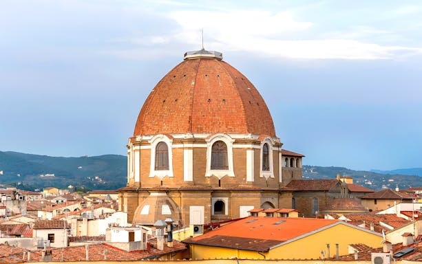 Medici Chapels dome in Florence with city rooftops in the foreground.