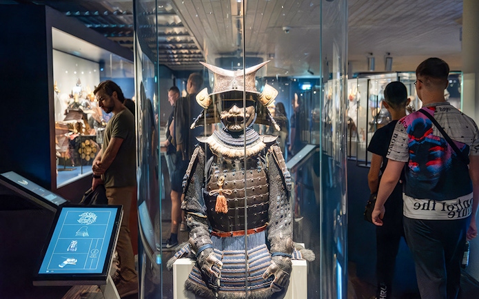 Samurai armor display at the Samurai Museum with visitors exploring exhibits.
