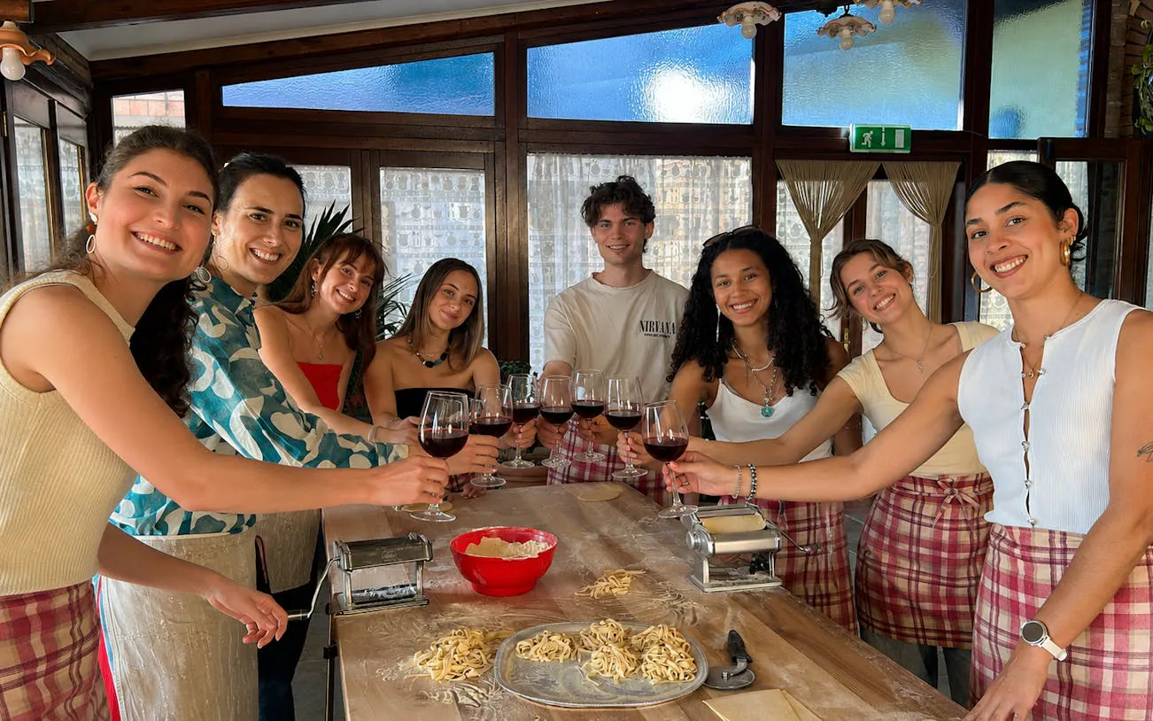 Group enjoying pasta making class with wine at Amalfi Coast farmhouse.