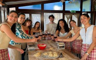 Group enjoying pasta making class with wine at Amalfi Coast farmhouse.
