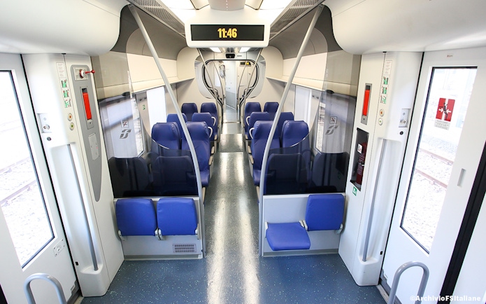 Interior of a train with blue seats, connecting Fiumicino Airport and Rome Termini Station.
