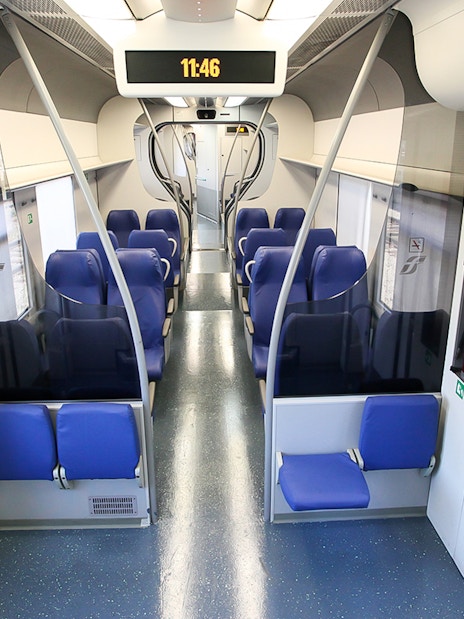 Interior of a train with blue seats, connecting Fiumicino Airport and Rome Termini Station.