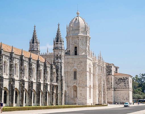 Jeronimos Monastery Lisbon exterior with tourists exploring the historic architecture.