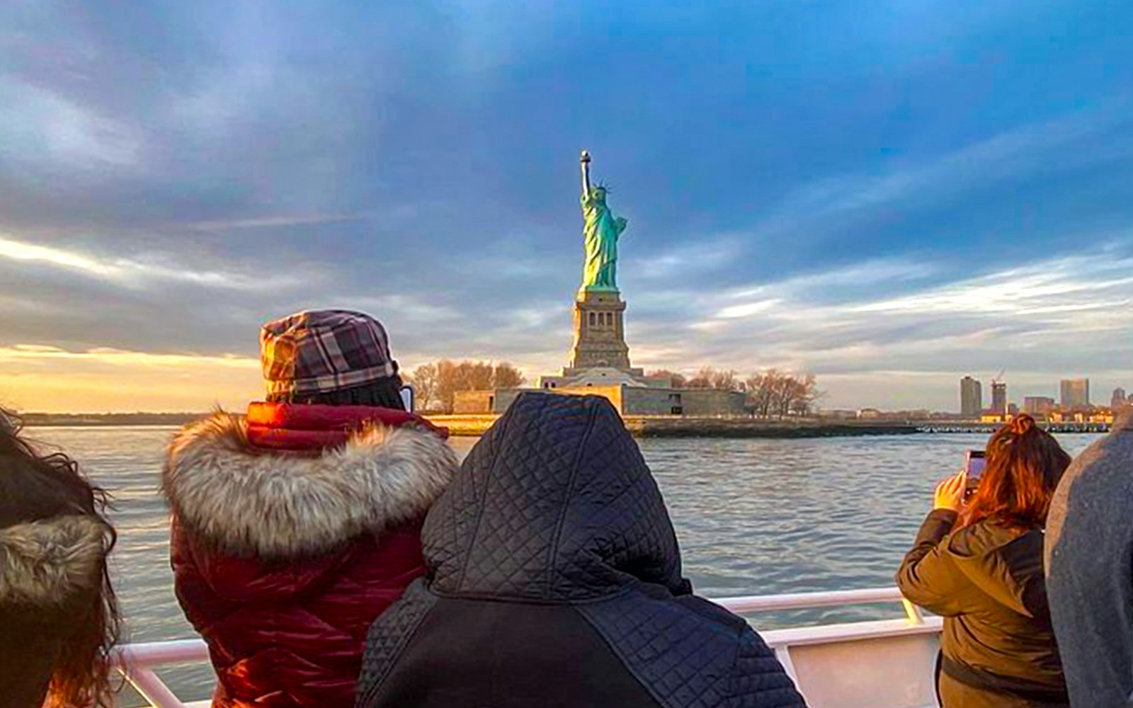 Sunset view of the Statue of Liberty from the Ellis Island Sunset Cruise, a unique New York City tour experience