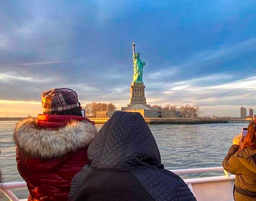Sunset view of the Statue of Liberty from the Ellis Island Sunset Cruise, a unique New York City tour experience