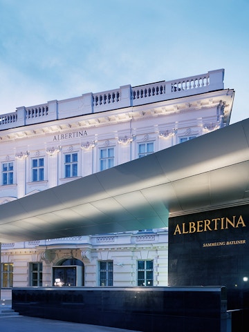 Albertina Museum entrance with illuminated facade in Vienna.