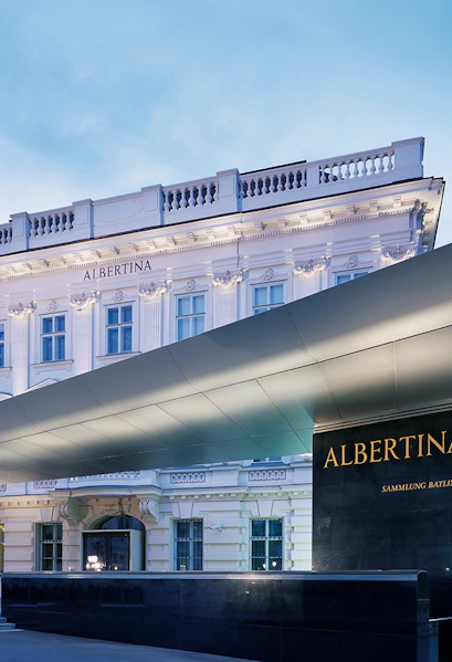 Albertina Museum entrance with illuminated facade in Vienna.