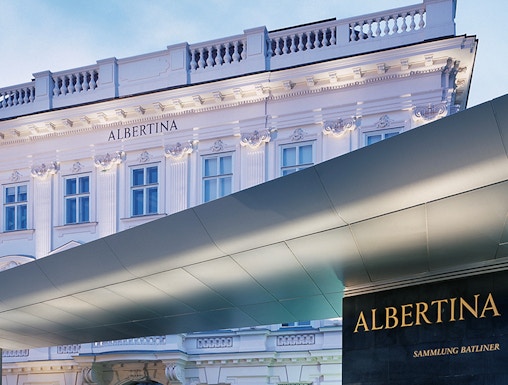 Albertina Museum entrance with illuminated facade in Vienna.