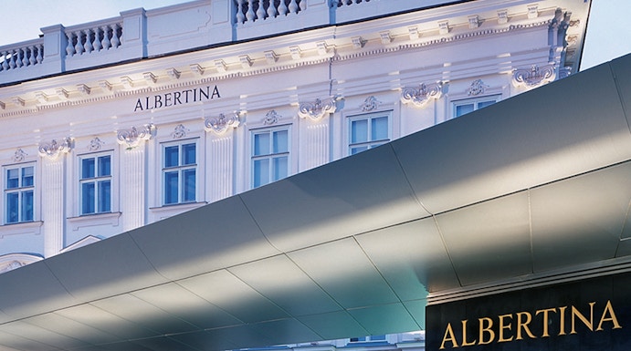 Albertina Museum entrance with illuminated facade in Vienna.