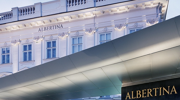 Albertina Museum entrance with illuminated facade in Vienna.