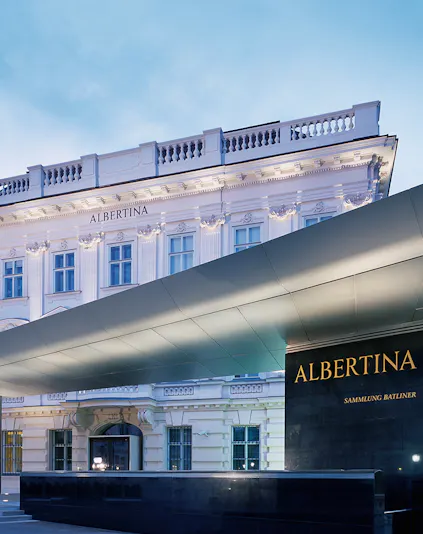 Albertina Museum entrance with illuminated facade in Vienna.